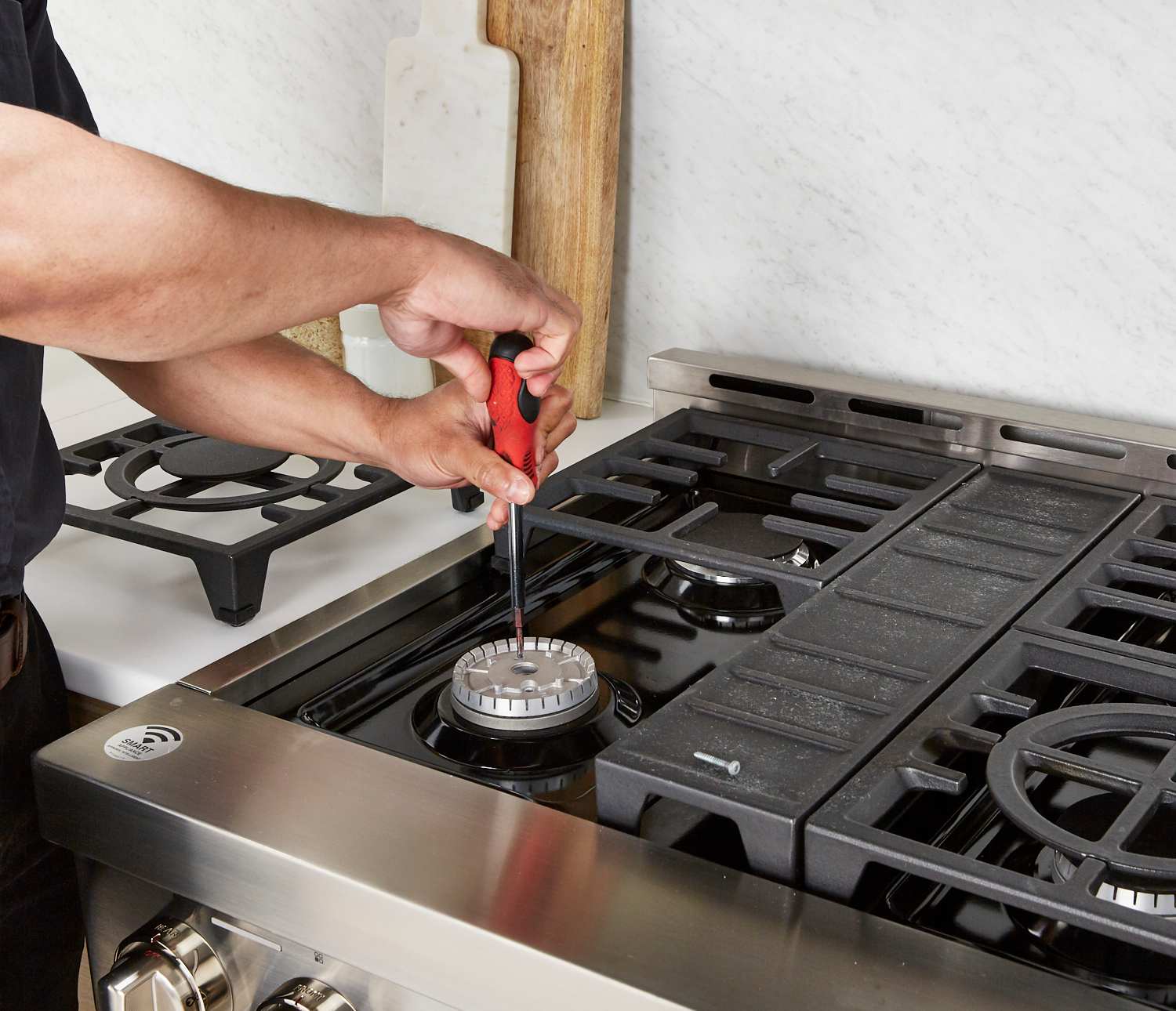 Technician repairing a gas stove burner