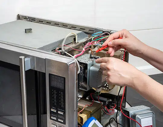 Technician servicing a microwave oven
